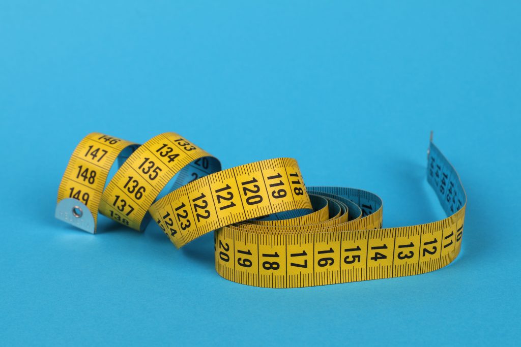 Uitgerold geel meetlint met centimeterverdeling