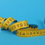 Uitgerold geel meetlint met centimeterverdeling