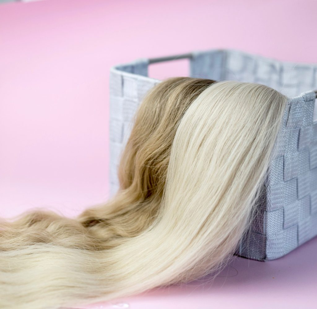 Blonde en bruine haarlokken naast elkaar op een mand