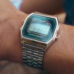 Digitaal horloge met metalen schakelband om een pols