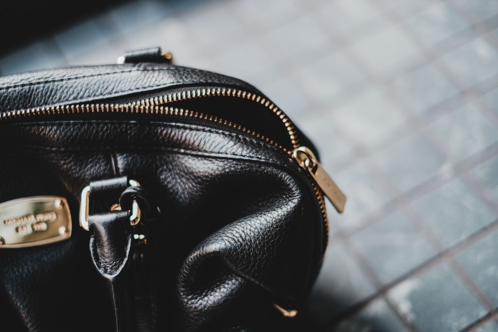 Close-up van een zwarte leren tas met rits en label