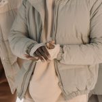Close-up van een beige gewatteerde donsjas met rits